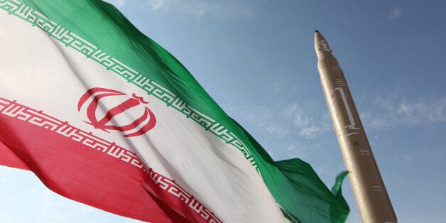 A picture taken on August 20, 2010 shows an Iranian flag fluttering at an undisclosed location in the Islamic republic next to a surface-to-surface Qiam-1 (Rising) missile which was test fired a day before Iran was due to launch its Russian-built first nuclear power plant. Iranian Defence Minister Ahmad Vahidi said the missile was entirely designed and built domestically and powered by liquid fuel. AFP PHOTO/VAHID REZA ALAEI (Photo credit should read VAHID REZA ALAEI/AFP/Getty Images)