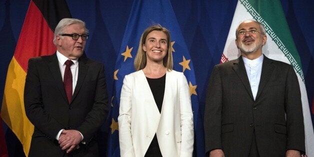 Iranian Foreign Minister Javad Zarif (R) waits to make a statement flanked by German Foreign Minister Frank Walter Steinmeier (L) and European Union High Representative for Foreign Affairs and Security Policy Federica Mogherini at the Swiss Federal Institute of Technology in Lausanne (Ecole Polytechnique Federale De Lausanne) on April 2, 2015, after Iran nuclear program talks finished with extended sessions. European powers and Iran on April 2 hailed a breakthrough in talks on reaching a deal to curtail Tehran's nuclear programme. AFP PHOTO / POOL / BRENDAN SMIALOWSKI (Photo credit should read BRENDAN SMIALOWSKI/AFP/Getty Images)