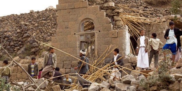 Yemenis gather as they search for survivors in the rubble of houses destroyed by Saudi-led airstrikes in a village near Sanaa