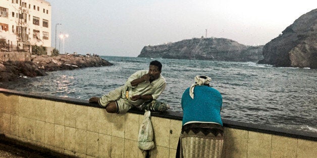 In this Monday, March 16, 2015 photo, men chew qat, a mildly narcotic leaf, by the Arabian Sea coast in Aden, Yemen. Calls am