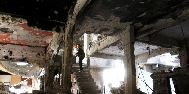 A man stands on a staircase inside a demolished building in the Yarmuk Palestinian refugee camp in the Syrian capital Damascus on April 6, 2015. Around 2,000 people have been evacuated from the camp after the Islamic State group seized large parts of it. At least 26 people, including civilians as well as fighters from IS and Palestinian factions, had been killed in the camp according to the Syrian Observatory for Human Rights. AFP PHOTO / YOUSSEF KARWASHAN (Photo credit should read YOUSSEF KARWASHAN/AFP/Getty Images)