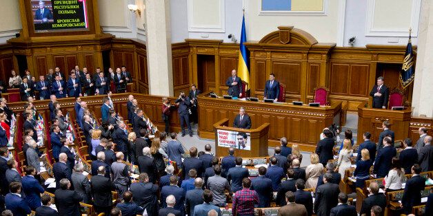 Ukrainian lawmakers greet Poland's President Bronislaw Komorowski, center, in Parliament in Kiev, Ukraine, Thursday, April 9, 2015.