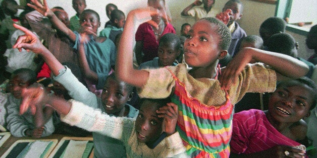 Rwandan primary school children answer their teacher's question with enthusiasm on their first day back at Nyamagumba School in Ruhengeri, 60 miles northwest of Kigali, Rwanda, Monday, Sept. 19, 1994. The school reopens after being shut down during tribal warfare which started in April. The students will study with school supplies donated by UNICEF and UNESCO. One third of the former students showed up for school while many of their classmates were killed in ethnic massacres and others fled with their families to Zaire. (AP Photo/Jean-Marc Bouju)