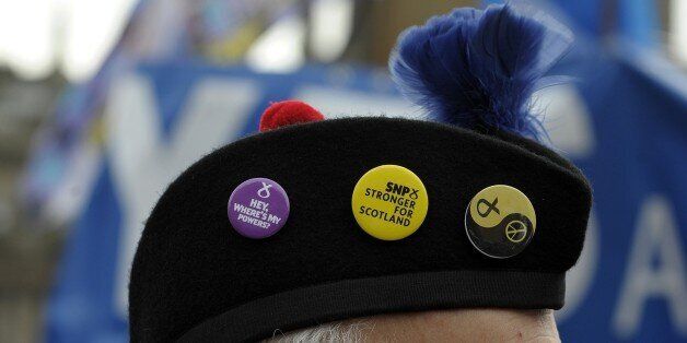 A protester at a rally against the Trident nuclear programme wears an a badge of the Scottish National Party (SNP) in the centre of Glasgow, Scotland, on April 4, 2015. AFP PHOTO / ANDY BUCHANAN (Photo credit should read Andy Buchanan/AFP/Getty Images)