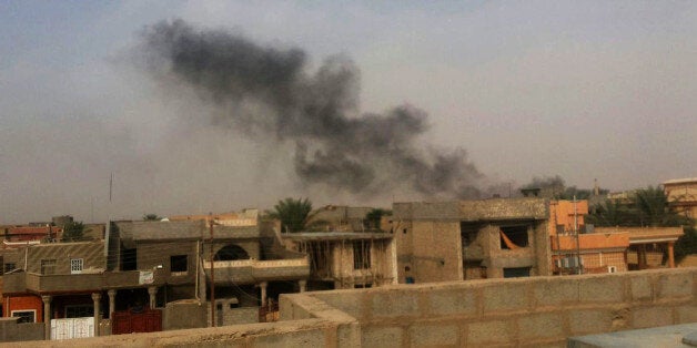 Smoke plumes are visible over buildings in the Iraqi town of Hit, in western Anbar province - 140 kilometers (85 miles) west