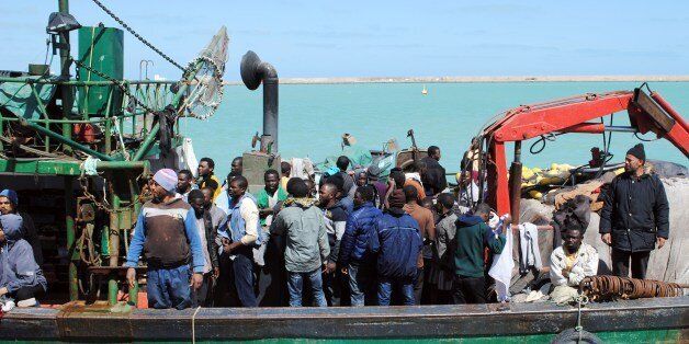 Illegal African migrants arrive at the port in the Tunisian town of Zarzis, some 50 kilometres west of the Libyan border, on March 19, 2015, after Tunisian fishermen rescued 82 African migrants off the coast of the town aboard a makeshift boat bound for the Italian island of Lampedusa. The group were fleeing the conflict in neighbouring Libya. AFP PHOTO / FETHI NASRI (Photo credit should read FETHI NASRI/AFP/Getty Images)
