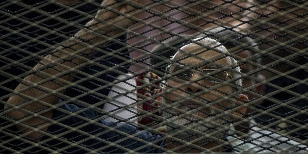 Egyptian Muslim Brotherhood leader Mohamed Badie gestures as he shouts from inside the defendants cage during his trial in th