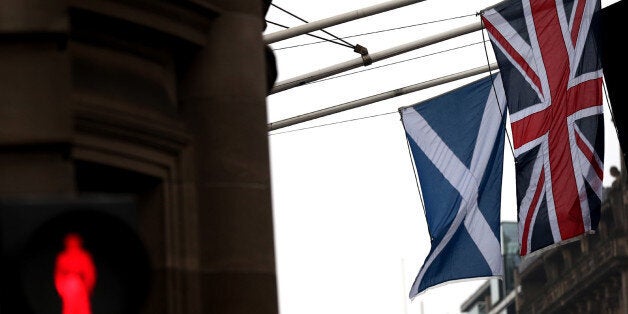 A Saltire and Union Jack flag hang side by side on a building in Edinburgh, Scotland, Friday, Sept. 19, 2014. Scottish voters