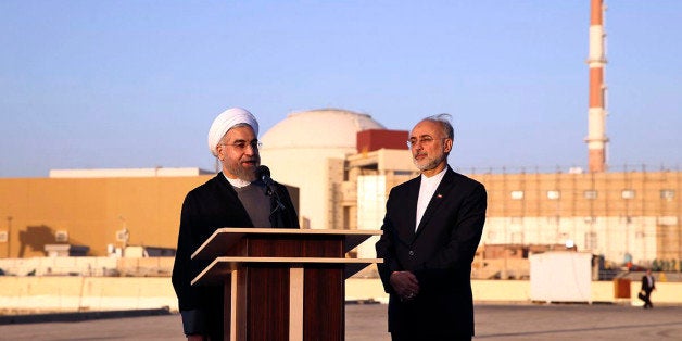 In this photo released by the Iranian Presidency Office, President Hassan Rouhani, left, speaks as he is accompanied by the h