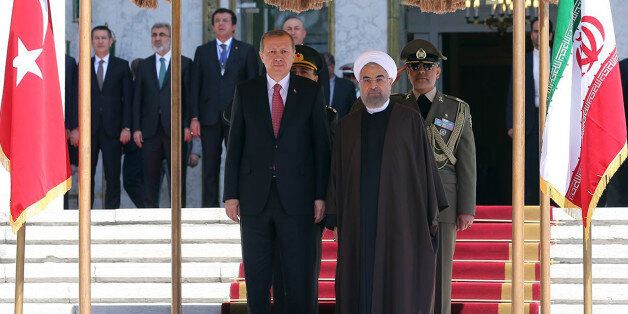 In this photo released by the official website of the office of the Iranian Presidency, Iran's President Hassan Rouhani, right, and his Turkish counterpart Recep Tayyip Erdogan listen to their countries' national anthems during a welcoming ceremony for Erdogan at the Saadabad palace in Tehran, Iran, Tuesday, April 7, 2015. Turkish President Recep Tayyip Erdogan is visiting Iran despite tensions with Tehran over the crisis in Yemen, where airstrikes by a Saudi-led coalition are targeting Iran-backed Shiite rebels who have taken over much of the country. (AP Photo/ Iranian Presidency Office)