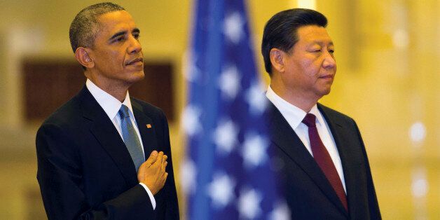U.S. President Barack Obama places his hand on his chest as the U.S. national anthem is played at a welcome ceremony with Chinese President Xi Jinping inside the Great Hall of the People in Beijing Wednesday, Nov. 12, 2014. (AP Photo/Ng Han Guan)