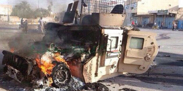 In this Sunday, Oct. 5, 2014. photo, an Iraqi military vehicle burns after an attack by the militant Islamic State group, in western Anbar province, 140 kilometers (85 miles) west of Baghdad, Iraq. Islamic State group fighters stormed Hit on Thursday, its latest victory against the embattled Iraqi military in Anbar province. (AP Photo)