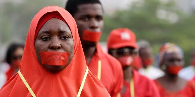 People march during a silent protest calling on the government to rescue the kidnapped girls of the government secondary school in Chibok, who were abducted a year ago, in Abuja, Nigeria, Monday, April 13, 2015. Nearly 300 schoolgirls from Chibok were abducted in a mass kidnapping on the night of April 14-15. Dozens escaped on their own but 219 remain missing. (AP Photo/Sunday Alamba)