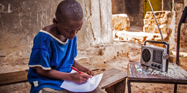 In this photo taken on Thursday, Feb. 26, 2015, a boy listens to school classes broadcast over the radio, due to the Ebola virus outbreak in Sierra Leone schools across the country have been closed in an effort to prevent the spread of the virus in Freetown, Sierra Leone. According to the head of the national Ebola response Centre, complacent behavior in Sierra Leone has led to a worrying spike in confirmed Ebola cases over the past week in four districts, Alfred Palo Conteh said Thursday, March 12, 2015. (AP Photo/ Michael Duff)