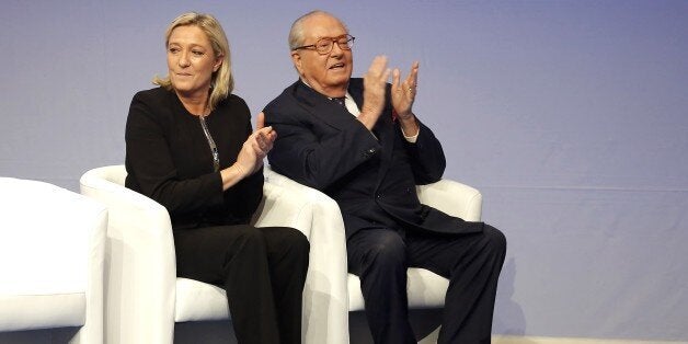 FILE - In this Saturday Nov. 29, 2014 file photo, French far-right Front National leader Marine Le Pen and her father Jean-Marie Le Pen applaud during the 15th congress of the party, in Lyon, central France. Marine Le Pen has launched an all-out offensive against her father, party founder Jean-Marie Le Pen, saying she will oppose his candidacy in upcoming elections and condemning as "political suicide" his repeated comments that the Nazi gas chambers were a "detail in history." (AP Photo/Laurent Cipriani, File)