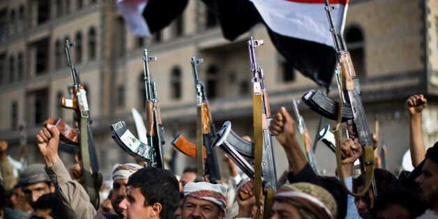 FILE - In this Friday, April 10, 2015 file photo, Shiite rebels, known as Houthis, hold up their weapons as they attend a protest against Saudi-led airstrikes in Sanaa, Yemen. Pakistani lawmakers on Friday unanimously voted to stay out of the Saudi-led air coalition targeting Shiite rebels in Yemen in a blow to the alliance, while planes loaded with badly needed medical aid landed in Yemen's embattled capital, Sanaa, in the first such deliveries since the airstrikes started more than two weeks ago. (AP Photo/Hani Mohammed, File)