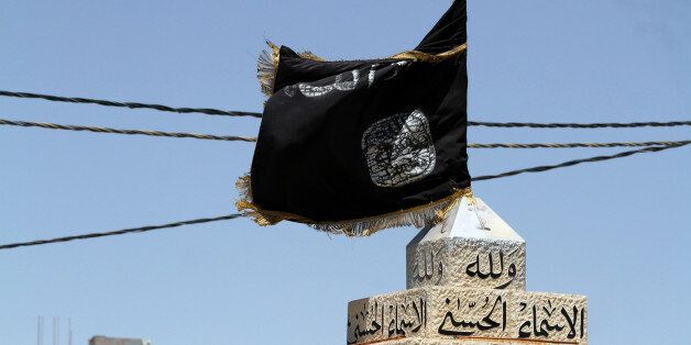 An Islamist flag flaps in the main square in Maan, 218 kilometers (135.5 miles) southwest of Amman, Jordan, Friday, July 4, 2014. Mohammed al-Shalabi, a Jordanian militant leader linked to al-Qaida, said Friday that the kingdom "is not immune" to the chaos befalling neighboring countries, urging the government to implement more balanced economic and social policies to avoid a fate similar to Iraq and Syria. (AP Photo/Raad Adayleh)