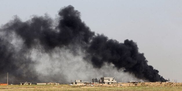 Smoke billows from what is believed to be an oil field which was set alight by Islamic State (IS) group militants in the Mkeishifa area, south of the northern Iraqi city of Tikrit, as government forces, supported by Popular Mobilization units, try to retake the area from Islamist rebels on April 9, 2015. AFP PHOTO / AHMAD AL-RUBAYE (Photo credit should read AHMAD AL-RUBAYE/AFP/Getty Images)