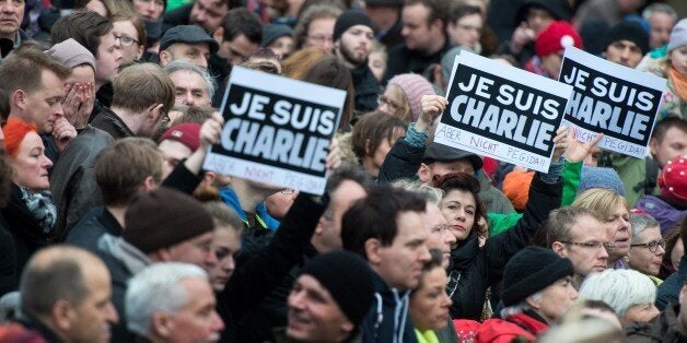 People hold up posters reading 'Je suis Charlie - Aber nicht Pegida' (I am Charlie - But not Pegida) during a rally themed 'For Dresden, for Saxony - living together in the sense of a global awareness, humanity and dialogue ' on January 10, 2015 in front of the Frauenkirche (Church of Our Lady) in Dresden, eastern Germany. The rally was organised as a response to the anti-Islamic Pegida movement, that plans to rally again on Monday, January 12, 2015. Analysts expect Pegida's ranks to swell by thousands following this week's bloody jihadist violence in France. AFP PHOTO / DPA / ARNO BURGI +++ GERMANY OUT (Photo credit should read ARNO BURGI/AFP/Getty Images)