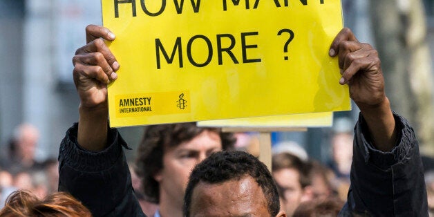 A protestor holds up a sign during a demonstration outside of an emergency EU summit in Brussels on Thursday, April 23, 2015. Protestors on Thursday called on EU leaders to take more effective action to save lives in the Mediterranean, where hundreds of migrants are missing and feared drowned in recent days. (AP Photo/Geert Vanden Wijngaert)