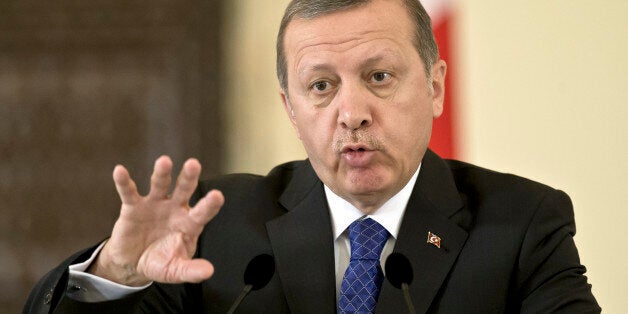 Turkish President Recep Tayyip Erdogan gestures during a brief press conference at the Cotroceni presidential palace in Bucharest, Romania, Wednesday, April 1, 2015. Two members of a banned leftist group and a prosecutor they held hostage inside a courthouse in Istanbul died Tuesday after a shootout between the hostage takers and police, officials said. Erdogan is on an official visit to Romania. (AP Photo/Vadim Ghirda)