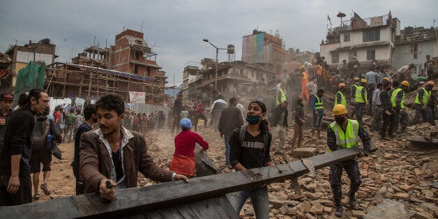 KATHMANDU, NEPAL - APRIL 25: Emergency rescue workers clear debris in Basantapur Durbar Square while searching for survivors on April 25, 2015 in Kathmandu, Nepal. More than 100 people have died as tremors hit Nepal after an earthquake measuring 7.9 on the Richter scale caused buildings to collapse and avalanches to be triggered in the Himalayas. Authorities have warned that the death toll is likely to be much higher. (Photo by Omar Havana/Getty Images)