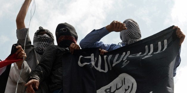 Kashmiri demonstrators hold up a flag of the Islamic State of Iraq and the Levant (ISIL) during a demonstration against Israe