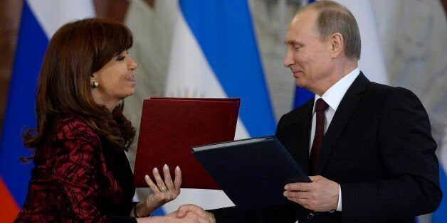 Russian President Vladimir Putin, right, and Argentina's President Cristina Fernandez exchange documents at a signing ceremony in the Kremlin in Moscow, Thursday, April 23, 2015. Fernandez in in Russia on an official visit. (Alexander Nemenov/ Pool Photo via AP)