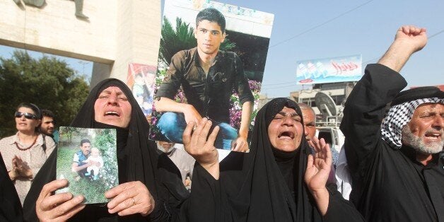 Iraqi women hold pictures of their relatives, who are believed to have been killed in the Speicher massacre, during a demonstration calling for government action, in the capital Baghdad, on April 27, 2015. The Islamic State (IS) jihadist group executed hundreds of mostly Shiite recruits last June in what is known as the Speicher massacre, named for the military base near which they were captured. Thirteen grave sites have been found -- 10 in the palace complex and three outside, Haider Majid, an employee of Prime Minister Haider al-Abadi's office working on the Speicher issue, said. AFP PHOTO / AHMAD AL-RUBAYE (Photo credit should read AHMAD AL-RUBAYE/AFP/Getty Images)