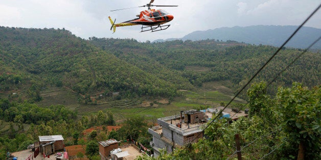 A chartered helicopter carrying injured villagers from Saturday's massive earthquake arrives from the heavily-damaged Ranachour village at a landing zone in the town of Gorkha, Nepal, Tuesday, April 28, 2015. Helicopters crisscrossed the skies above the high mountains of Gorkha district on Tuesday near the epicenter of the weekend earthquake, ferrying the injured to clinics, and taking emergency supplies back to remote villages devastated by the disaster. (AP Photo/Wally Santana)