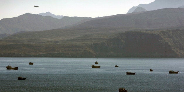 In this Jan. 19, 2012 photo, a plane flies over the mountains in south of the Strait of Hormuz as the trading dhows and ships