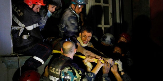 Survivor Rishi Khanal, 27, is freed by French rescuers from the ruins of a three-story hotel in the Gangabu area of Kathmandu
