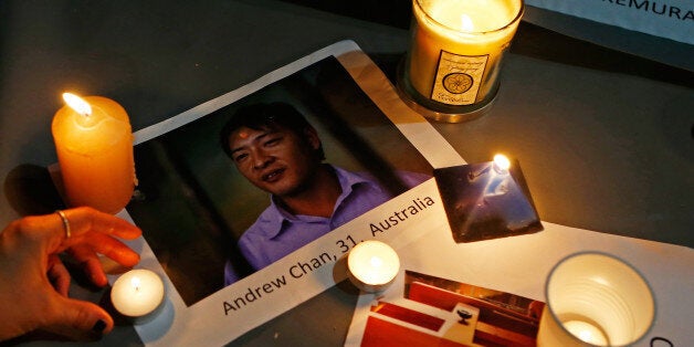 SYDNEY, AUSTRALIA - APRIL 28: A woman places a candle on top of a picture of Australian Andrew Chan, one of one of the priso