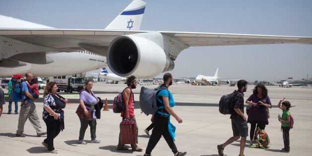 TEL AVIV, ISRAEL - APRIL 28: Israeli travelers with their new born babies from surrogate mothers in Nepal disembark from an Israeli rescue plane after it landed at Ben Gurion Airport on April 28, 2015 in Tel Aviv, Israel. A plane carrying 229 Israelis who were stranded in earthquake-hit Nepal landed at Tel Aviv's Ben Gurion International Airport early Tuesday afternoon. Among the passengers were 15 newborns, including three premature babies. (Photo by Lior Mizrahi/Getty Images)