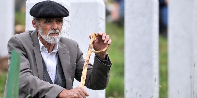 An elderly Bosnian Muslim man, survivor of the Srebrenica 1995 massacre, pays his respects at a relative's grave at the Srebrenica-Potocari Genocide Memorial cemetery in the village of Potocari near the eastern-Bosnian town of Srebrenica, on July 11, 2014. Several thousand people gathered on July 11 in Srebrenica for the 19th anniversary of the massacre of some 8,000 Muslim males by ethnic Serbs forces, Europe's worst atrocity since World War II. A total of 175 newly-identified massacre victims will be laid to rest after a commemoration ceremony held in Potocari, just outside the ill-fated Bosnian town. AFP PHOTO / ELVIS BARUKCIC (Photo credit should read ELVIS BARUKCIC/AFP/Getty Images)