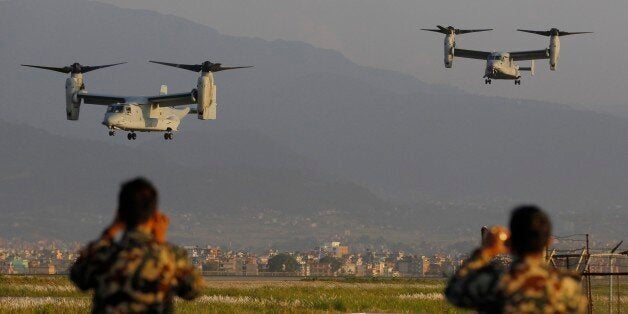 Nepalese soldiers take pictures as US Air Force Bell Boeing V-22 Osprey aircrafts arrive at the Tribhuvan International airport in Kathmandu, Nepal, Sunday, May 3, 2015. Runway damage forced Nepalese authorities to close the main airport Sunday to large aircraft delivering aid to millions of people following the massive earthquake, but U.N. officials said the overall logistics situation was improving. Airport congestion was only the latest complication in global efforts to aid people in the wake of the April 25 quake, the impoverished country's biggest and most destructive in eight decades. (AP Photo/Niranjan Shrestha)