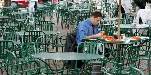 An unidentified patron eats lobsters at a deserted outdoor cafe in Faneuil Hall in Boston Tuesday, July 27, 2004. The Democratic Convention, and all the road closures it has brought, has driven a lot of people away from Boston for the week. (AP Photo/Winslow Townson)