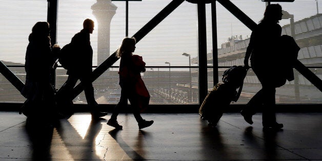 Travelers walk through terminal 3 at O'Hare International airport in Chicago, Sunday, Dec. 1, 2013. It's a holiday tradition for some families to fly over Thanksgiving, and traditionally there are long lines and big crowds. (AP Photo/Nam Y. Huh)