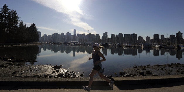 A woman joggs in Stanley Park in front of the Vancouver Skyline on February 19, 2010, during the Vancouver Winter Olympics.