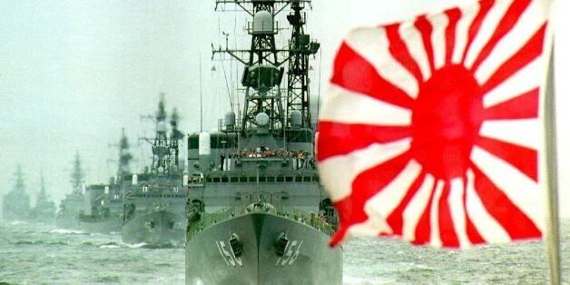SAGAMI BAY, JAPAN - OCTOBER 11: The flag of the Rising Sun, formerly used by the Japanese Imperial Navy and now used by the Japan Maritime Self Defense Force (MSDF), flutters in the wind while a fleet of the MSDF makes its way in Sagami Bay, south of Tokyo, during a fleet review to mark the 40th anniversary of the MSDF's founding 11 October, 1992. About 55 ships and 53 aircraft participated in the fleet review. (Photo credit should read TORU YAMANAKA/AFP/Getty Images)