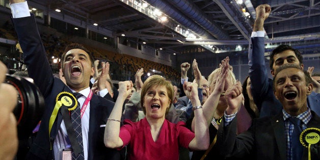 First Minister of Scotland and Scottish National Party leader Nicola Sturgeon, center, celebrates with the results for her party at the count of Glasgow constituencies for the general election in Glasgow, Scotland, Friday, May 8, 2015. The Conservative Party fared much better than expected in Britain's parliamentary election, with an exit poll and early returns suggesting that Prime Minister David Cameron would remain in his office at 10 Downing Street. The opposition Labour Party led by Ed Miliband took a beating, according to the exit poll, much of it due to the rise of the separatist Scottish National Party. (AP Photo/Scott Heppell)