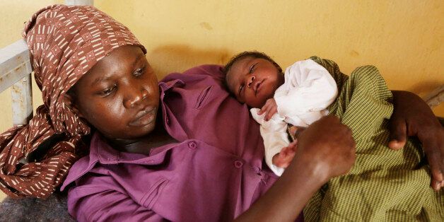 Lami Musa, 27-year-old who says her husband was killed before she was abducted by Islamist extremists, cradles her 5-day-old baby girl at a refugee camp clinic after she and others were rescued by Nigerian soldiers from Sambisa Forest, Yola, Nigeria Monday, May 4, 2015. Even with the crackle of gunfire signaling rescuers were near, the horrors did not end: Boko Haram fighters stoned captives to death, some girls and women were crushed by an armored car and three died when a land mine exploded as they walked to freedom. Through tears, smiles and eyes filled with pain, the survivors of months in the hands of the Islamic extremists told their tragic stories to The Associated Press on Sunday, their first day out of the war zone. "We just have to give praise to God that we are alive, those of us who have survived," said 27-year-old Lami Musa. (AP Photo/Sunday Alamba)
