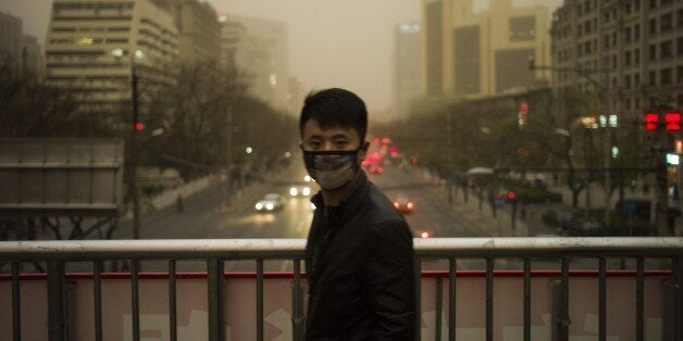 A man wears a facemask during a sandstorm in Beijing on April 15, 2015. Beijing's meteorological observatory issued a yellow