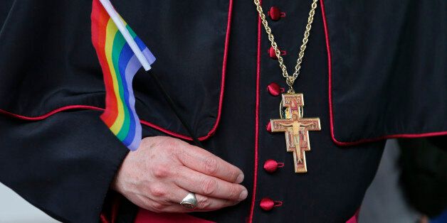 Rev. Roger LaRade, of the Eucharistic Catholic Church in Canada, carries a gay pride flag before giving blessings to couples from the LGBT community in Havana, Cuba, Saturday, May 9, 2015. The blessing ceremony on an island where gay marriage remains illegal was part of official ceremonies leading up to the Global Day against Homophobia on May 17. (AP Photo/Desmond Boylan)