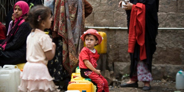 A girl waits for her turn to fill buckets with water from a public tap amid an acute shortage of water, in Sanaa, Yemen, Satu