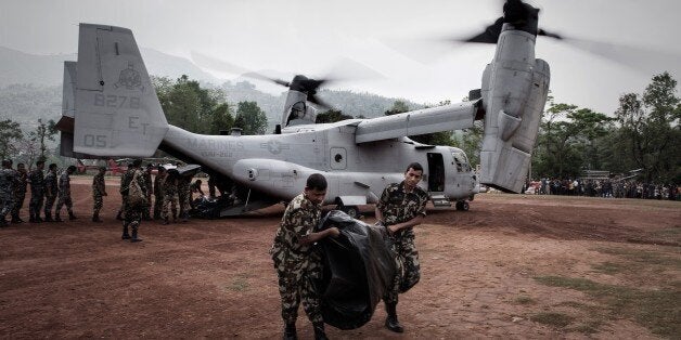 Nepalese soldiers unload relief supplies from an US Osprey aircraft at Dhading Besi, some 100 kms north west of Kathmandu on May 9, 2015. Following the 7.8 magnitude earthquake which struck the Himalayan nation on April 25, 2015, more than 131,500 Nepalese military and police personnel are taking part in the massive aid operation in the vast Himalayan nation, aided by more than 100 teams of foreign relief workers. AFP PHOTO/ Philippe Lopez (Photo credit should read PHILIPPE LOPEZ/AFP/Getty Images)