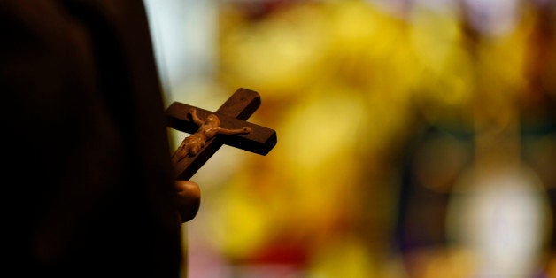 In this Dec. 1, 2012 photo, a statue with a crucifix and a stained glass window is seen inside a Catholic Church in New Orleans. Catholic groups are decrying a recent Louisiana Supreme Court decision that reaches into the most sanctified of Catholic places, the confessional booth. The high court has revived a sex abuse lawsuit in which parents are suing a priest and a local diocese for not reporting the alleged abuse when the teenager told the priest about it, and the ruling could have a priest asked to testify about what was said in a private confession. The Catholic League for Religious and Civil Rights says the ruling leaves the priest choosing between prison and excommunication, in a case that has grabbed attention in heavily Catholic south Louisiana. (AP Photo/Gerald Herbert)