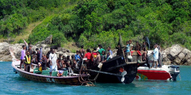 In this photo taken Jan. 1, 2013, a boat carrying 73 Rohingya refugees is intercepted by Thai authorities off the sea in Phuket, southern Thailand. Officials said the refugees from Myanmar's Rohingya minority found adrift off a Thai resort island will be repatriated to their homeland. Phuket provincial Governor Maitri Inthusut said Wednesday they declared they were unable to continue their hoped-for journey to Malaysia due to exhaustion and fear of mishaps at sea. (AP Photo)