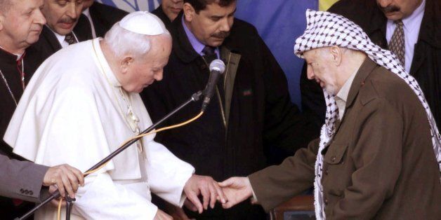 Palestinian leader, Yasser Arafat, touches the hand of Pope John Paul II during their meeting in Bethlehem Wednesday, March 22, 2000. Prior to this, the Pope visited the Dheisheh refugee camp. Pope John Paul II is on a six day visit of the Holy Land, the first visit by a Roman Catholic pontiff in 36 years. (AP Photo/Jerome Delay)