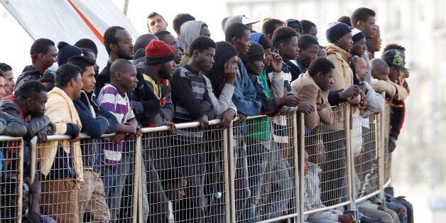 FILE - In this May 6, 2015, file photo, migrants wait to disembark from the Iceland Coast Guard vessel Tyr, at the Messina ha